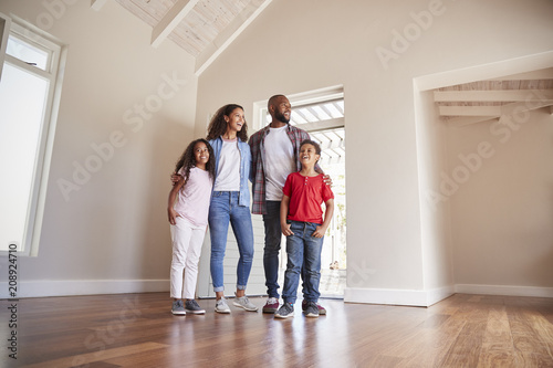 Family Opening Door And Walking In Empty Lounge Of New Home © Monkey Business