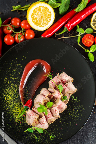 Fresh ham with sauce on black background
