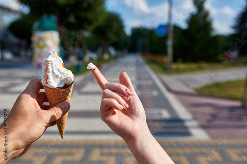 A first person view, sweethearts walking along the road with an ice cream in their hands, shallow depth of field.