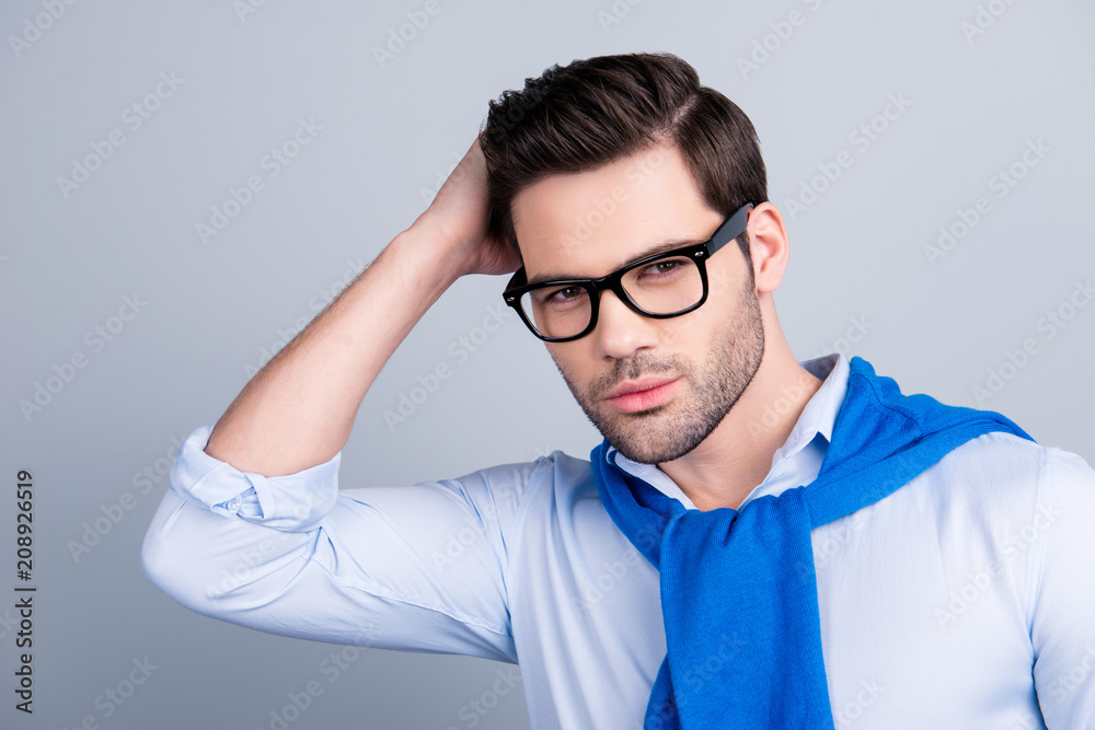 Stunning cool macho holding hand on his hair, correcting his hairstyle,  having tied blue sweater around the neck, looking at camera, isolated on  grey background Stock Photo | Adobe Stock