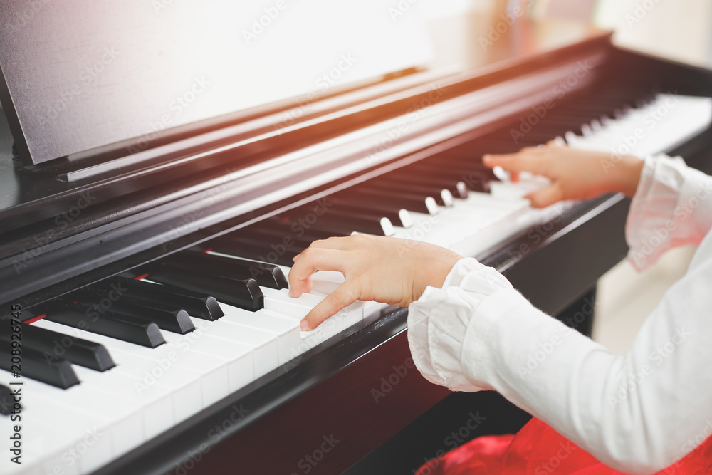 Fototapeta premium Little asian girl happy to play piano