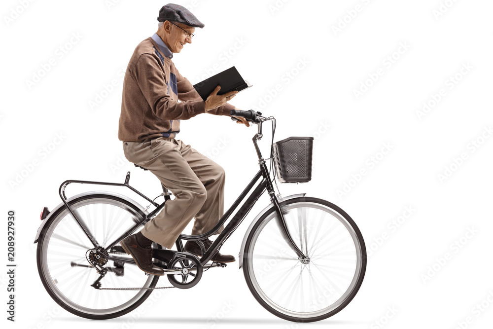 Obraz premium Elderly man riding a bicycle and reading a book