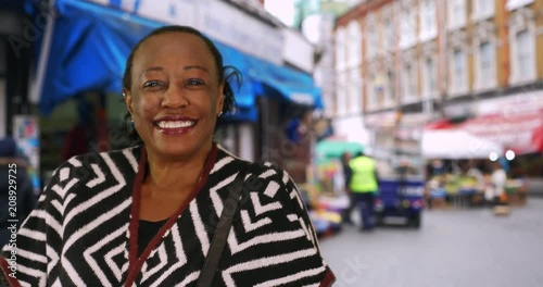 Portrait of cute senior woman at Brixton street market, Happy African American woman standing outdoors smiling at camera, 4k photo