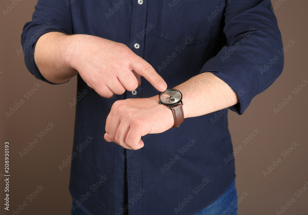 Man with wrist watch against color background. Time management concept Man with wrist watch against color background. Time management concept