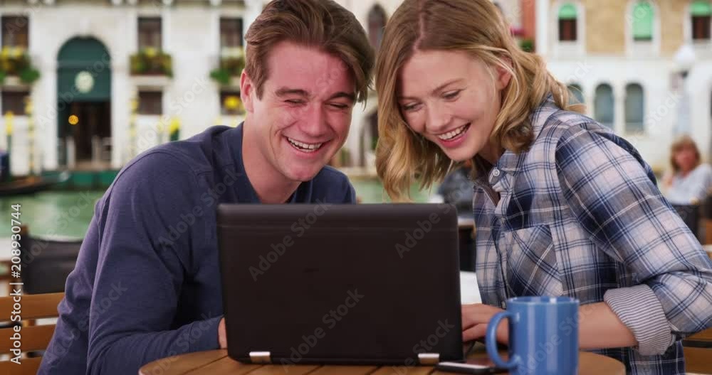Caucasian man and woman watching funny video on laptop, Two friends or happy couple using technology outdoors, 4k Caucasian man and woman watching funny video on laptop, Two friends or happy couple using technology outdoors, 4k