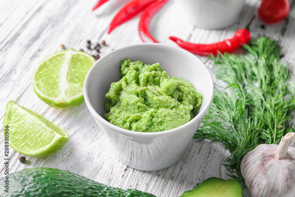 Bowl with tasty guacamole on wooden table Bowl with tasty guacamole on wooden table