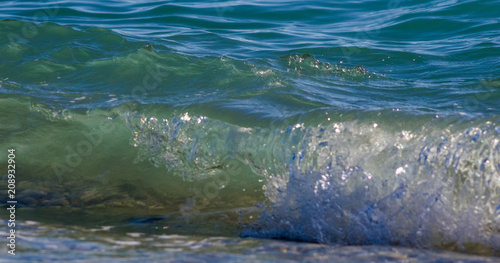 sea landscape is a pebbly beach with waves in white foam