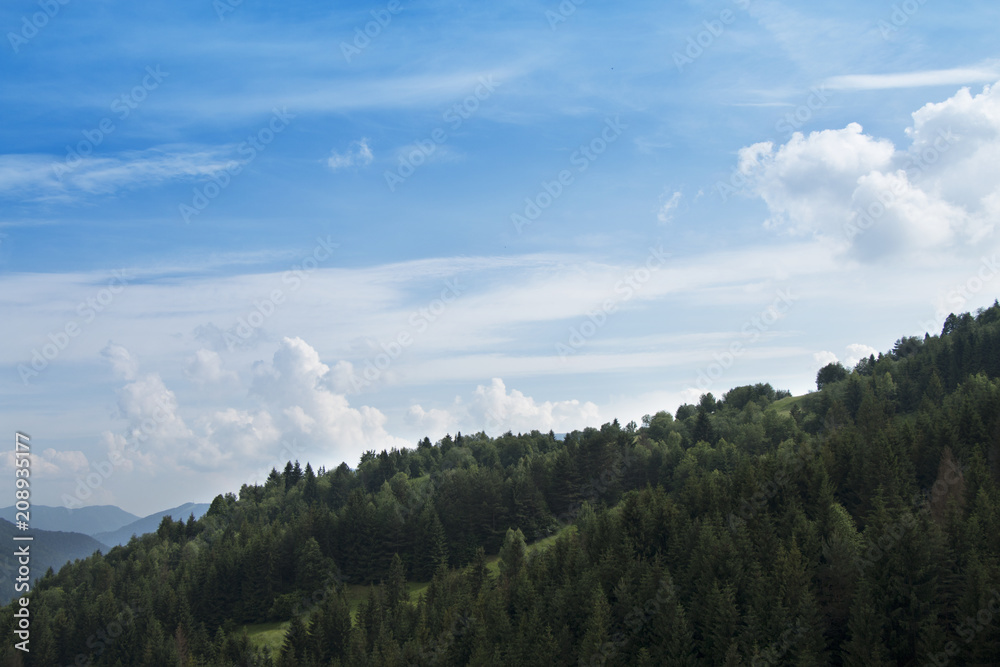Beautiful sunny landscape with hills and forests and clouds in the blue sky in Slovakia