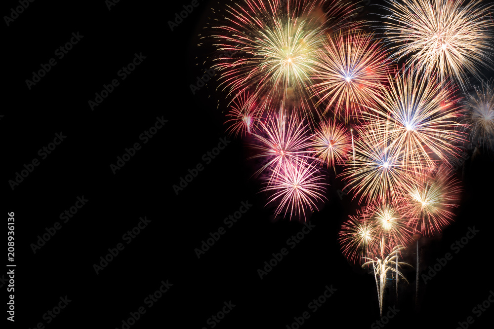 Abstract beautiful colorful fireworks display for celebration on black background with free space for text. New year holiday concept.