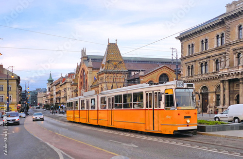 Budapest street with old yellow tram and classic buildings and architecture with city traffic. Hungary 