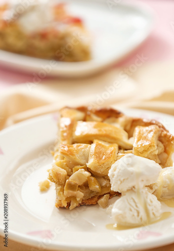 Piece of tasty homemade apple pie with ice cream on plate, closeup