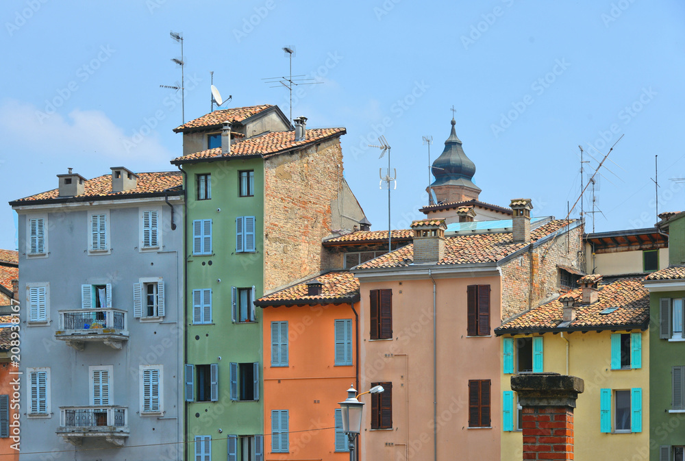 parma colorful buildings and facades in front of city open market with cloudy blue sky, Italy
