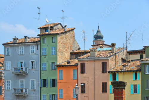 parma colorful buildings and facades in front of city open market with cloudy blue sky, Italy