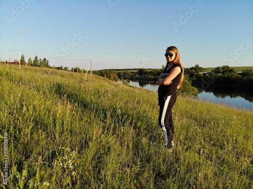A girl is posing near a lake on a hill. aerial photography.