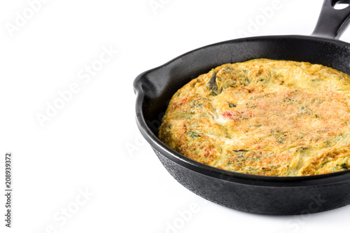 Frittata made of eggs and vegetables in a iron pan, isolated on white background. Copyspace


