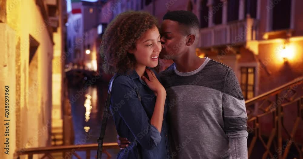 Happy and attractive black couple sightseeing in Venice at night, African American man and woman standing on bridge smile and point, 4k Happy and attractive black couple sightseeing in Venice at night, African American man and woman standing on bridge smile and point, 4k
