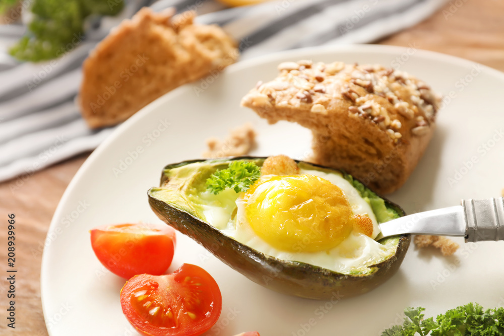 Baked avocado with eggs and vegetables on table, closeup Baked avocado with eggs and vegetables on table, closeup