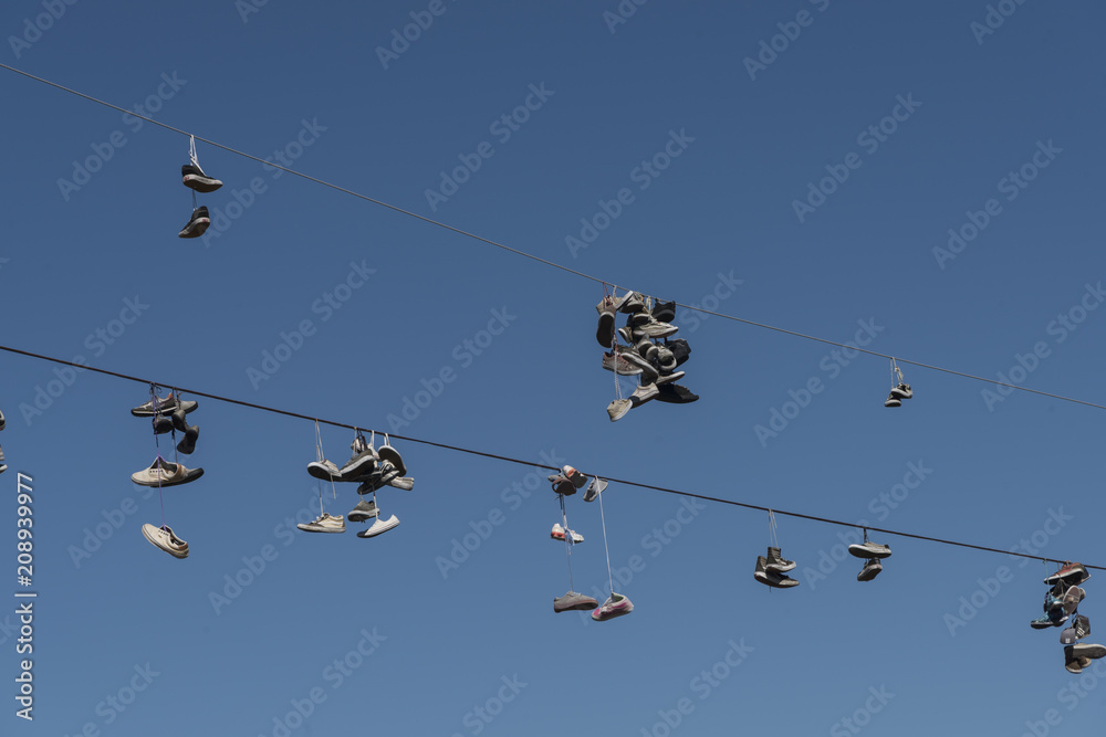 Low angle view of shoes hanging on overhead wires, Tofino, Vancouver Island, British Columbia, Canada Low angle view of shoes hanging on overhead wires, Tofino, Vancouver Island, British Columbia, Canada