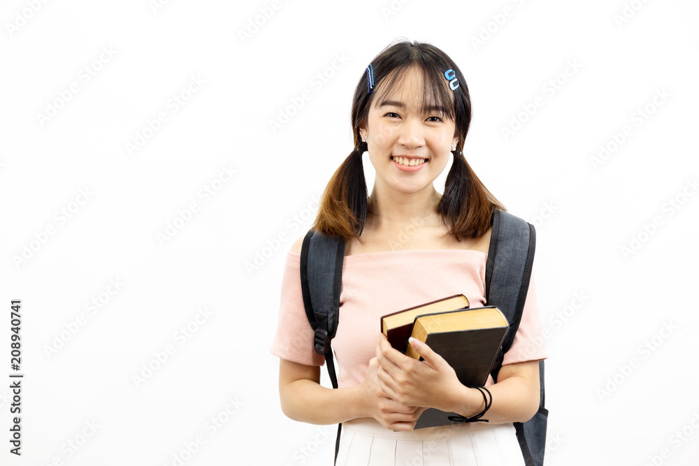 Smiling happy and casual Asian female college students holding pile of books with bag isolated over white background. Smiling happy and casual Asian female college students holding pile of books with bag isolated over white background.