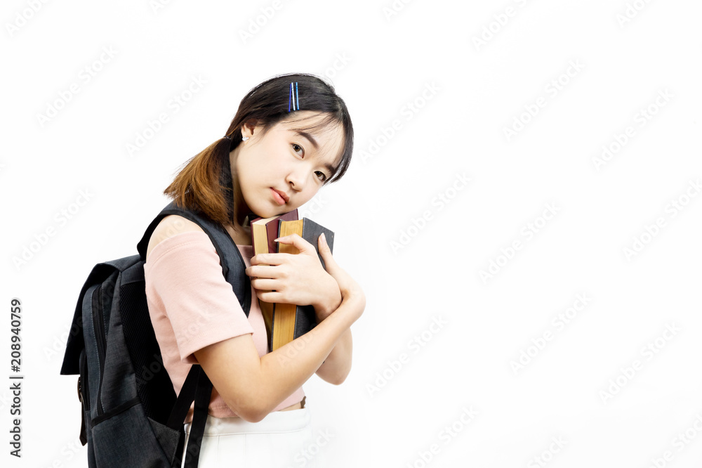 Young Asian female college students holding pile of books with bag isolated over white background Young Asian female college students holding pile of books with bag isolated over white background