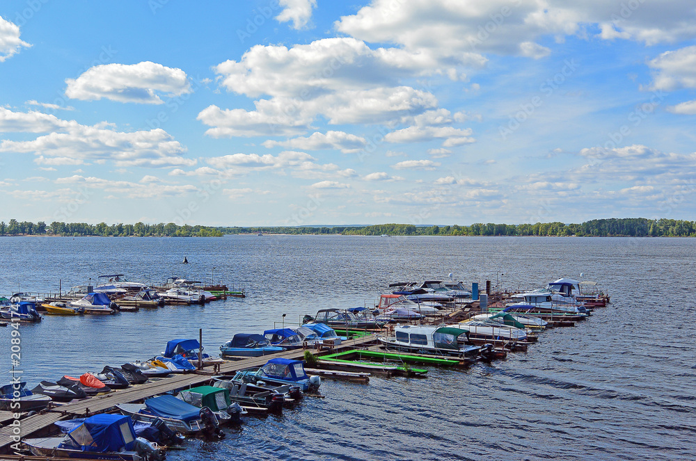Wooden pier with small boats docked to it. Samara, Russia, Volga river