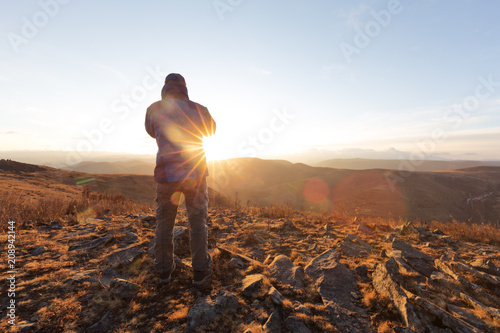 man take photo on top of mountain with sunrise