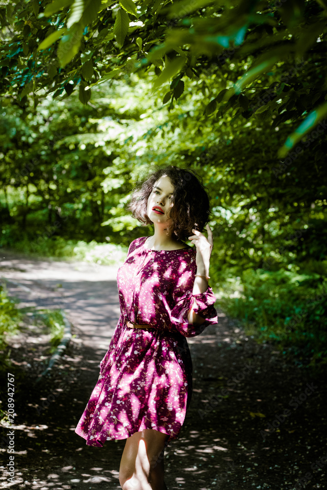 Beautiful girl with curly hair posing in the park Beautiful girl with curly hair posing in the park