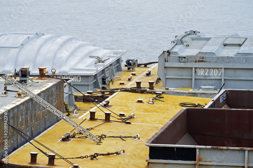 Photo of the coupling of four barges by thick cables photo