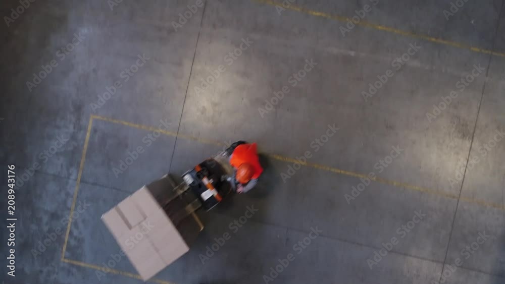 Aerial Drone Shot of Working Forklift Loader inside Logistic Warehouse. Shot in 4K (UHD).