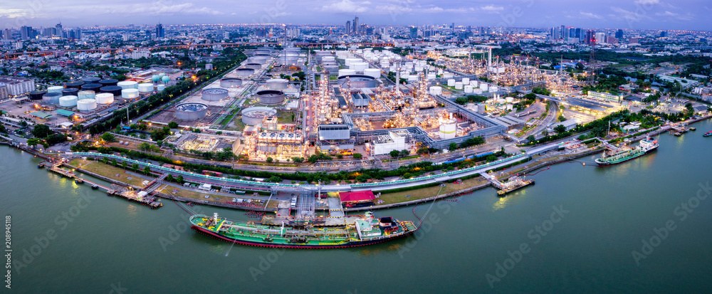 Aerial view of oil refinery near international port at night. Panorama of refinery plant at sunset. refinery factory and tank