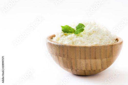 Fresh cottage cheese in a wooden bowl isolated on white background. Copyspace