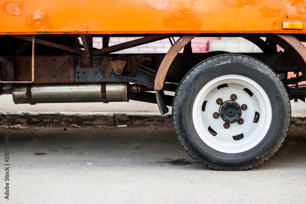 Naklejka premium Old truck's rear wheel and old rusty parts hiden under new painted body