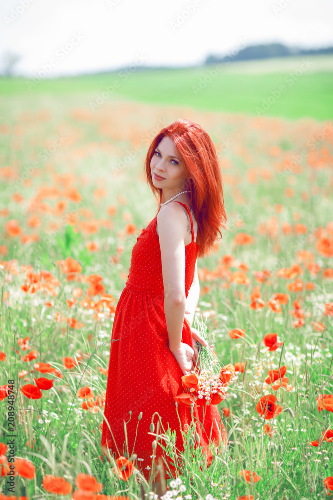 beautiful woman in red dress standing in a poppy field holding flowers ...