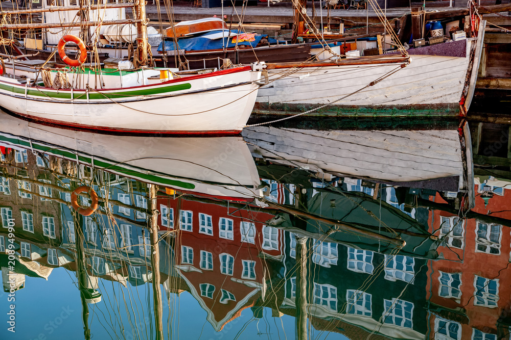 COPENHAGEN, DENMARK - MAY 6, 2018: historical buildings and boats reflected in calm water, copenhagen, denmark