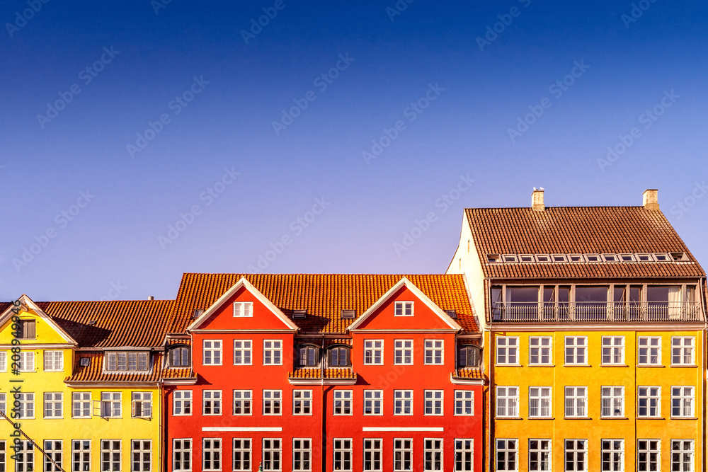beautiful colorful historical houses against blue sky in copenhagen, denmark