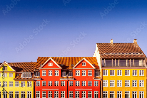 beautiful colorful historical houses against blue sky in copenhagen, denmark