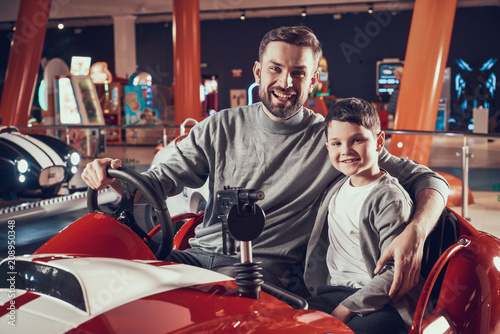 Happy smiling father and son sitting on toy car © freeograph