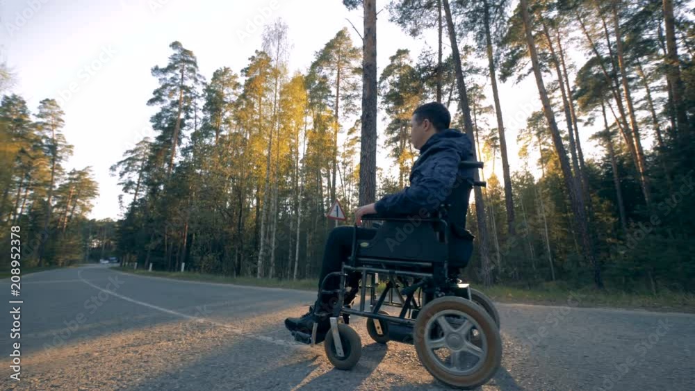 Disabled person in a powered wheelchair starts moving Disabled person in a powered wheelchair starts moving