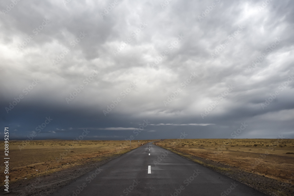 Empty asphalt road under stormy dramatic sky. Copy space for text or product