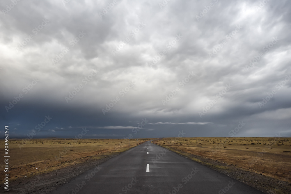 Empty asphalt road under stormy dramatic sky. Copy space for text or product Empty asphalt road under stormy dramatic sky. Copy space for text or product