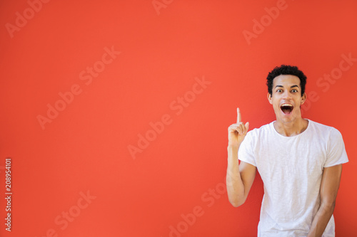 Excited young man pointing up his finger 