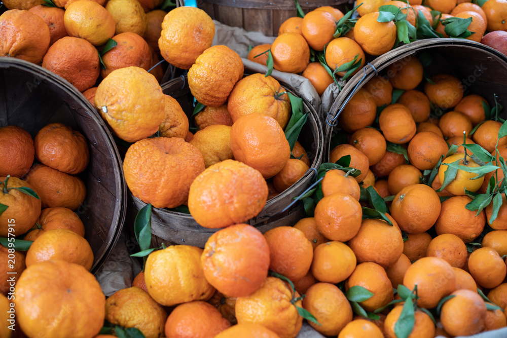 Juice and colorful citrus: lemons, oranges, grapefruits in baskets on a farmers market