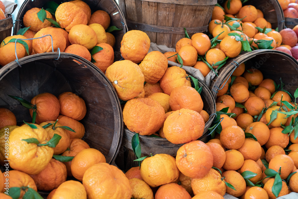 Juice and colorful citrus: lemons, oranges, grapefruits in baskets on a farmers market
