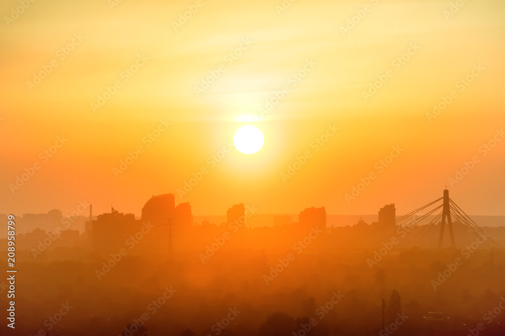 Sunset in the city. Skyline with orange sun on sky