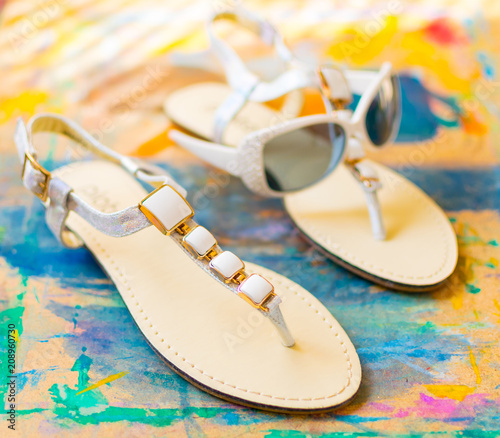 Female sandals on a multi-colored abstract background. The concept of summer, recreation.