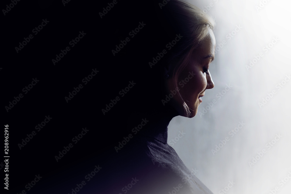 Portrait of a young calm woman in profile. Concept of the inner world and psychology, the dark and light side of personality. 