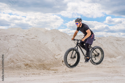  Training a bicyclist in a chalky quarry. A brutal man on a fat bike. © Mikhail