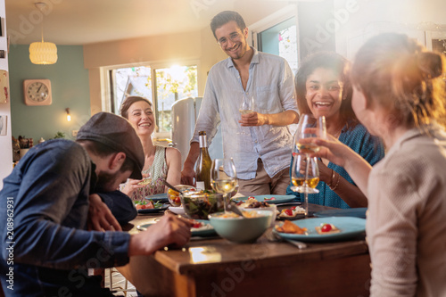 Mixed group of friends having fun while sharing a meal 