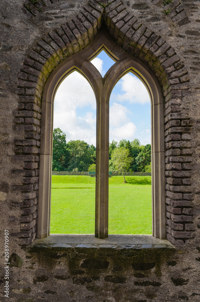 Fototapeta premium Stone window of a Norman Fort looking out to rural countryside.