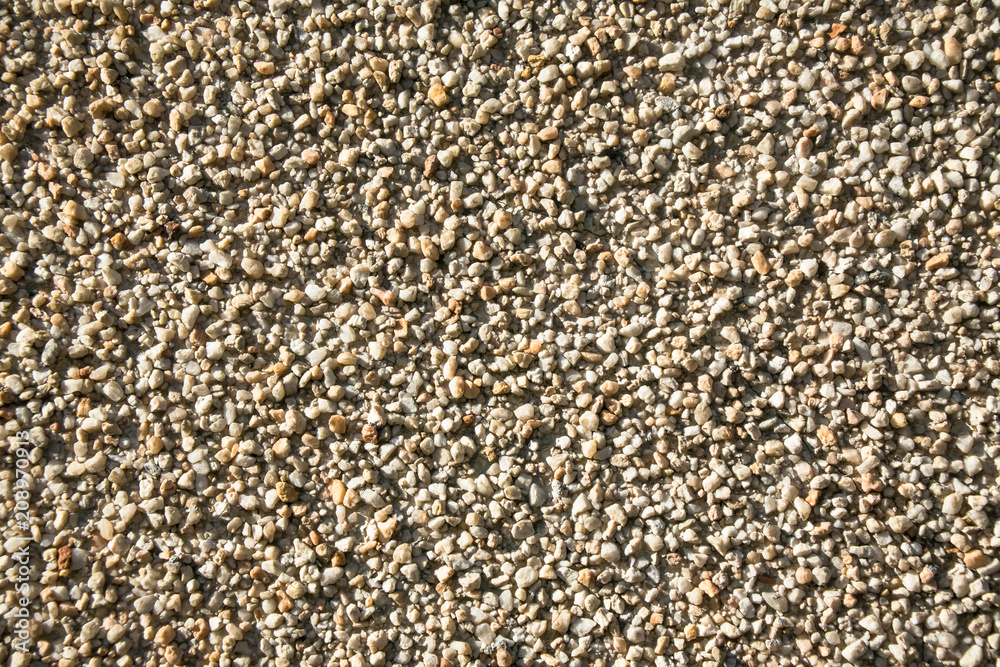 Fragment of an outdoor coating made of grey scabrous sand, closeup. Abstract grainy textured background. Fragment of an outdoor coating made of grey scabrous sand, closeup. Abstract grainy textured background.